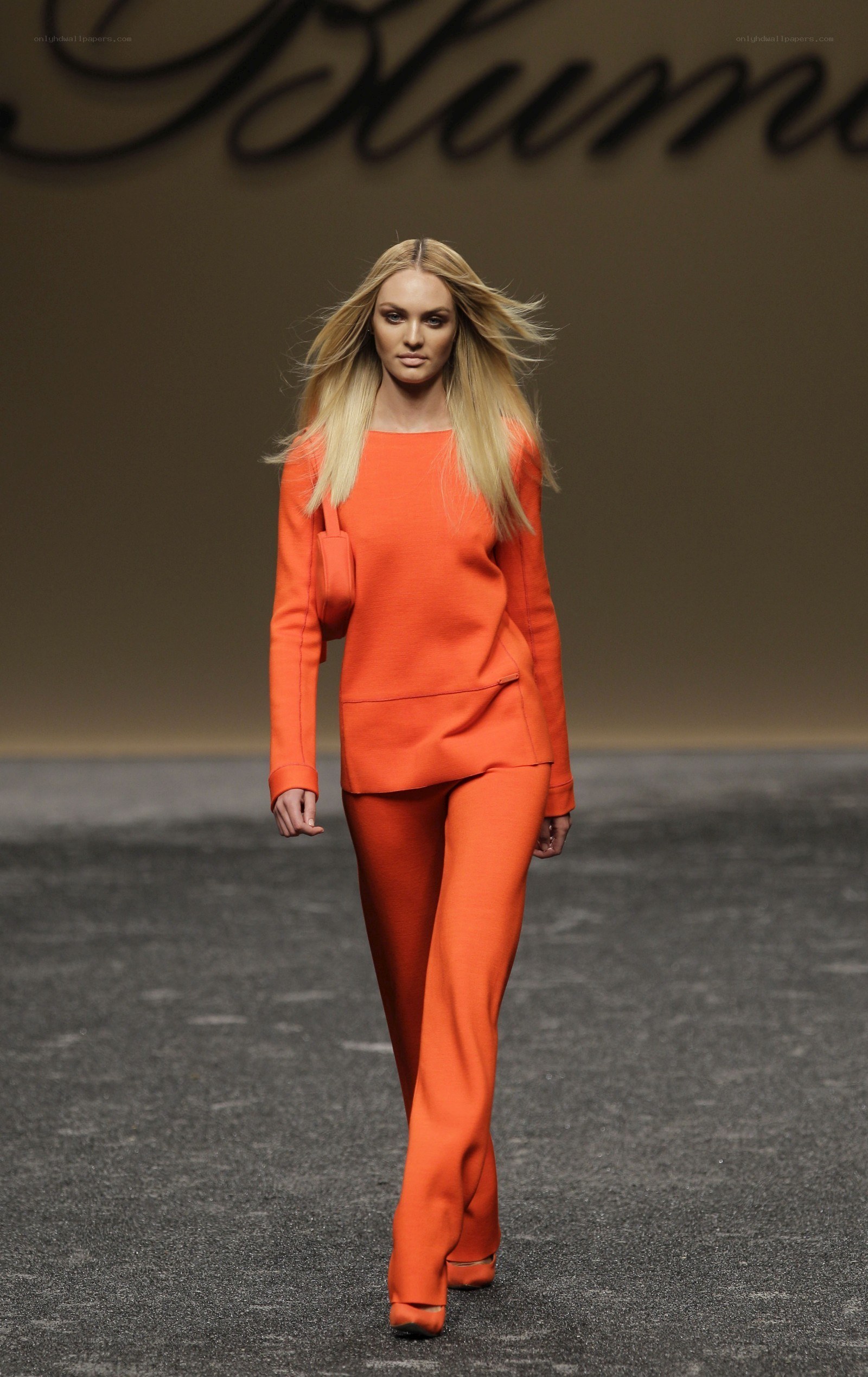 Model in orange suit on runway