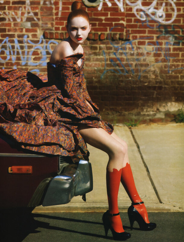 model in red dress on car