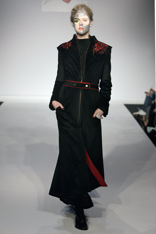 Model on runway in black coat