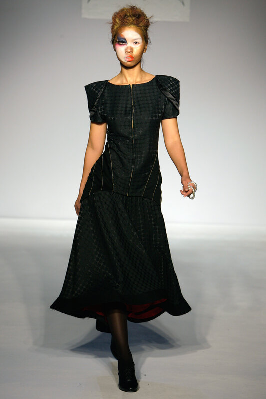 Model on runway in black dress