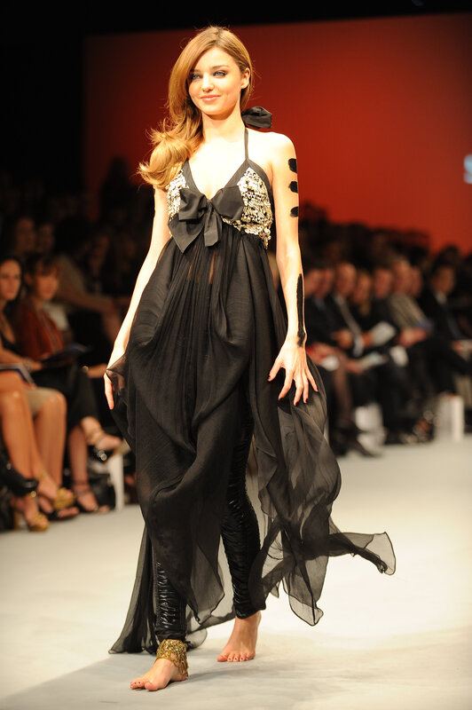 model on runway in black dress