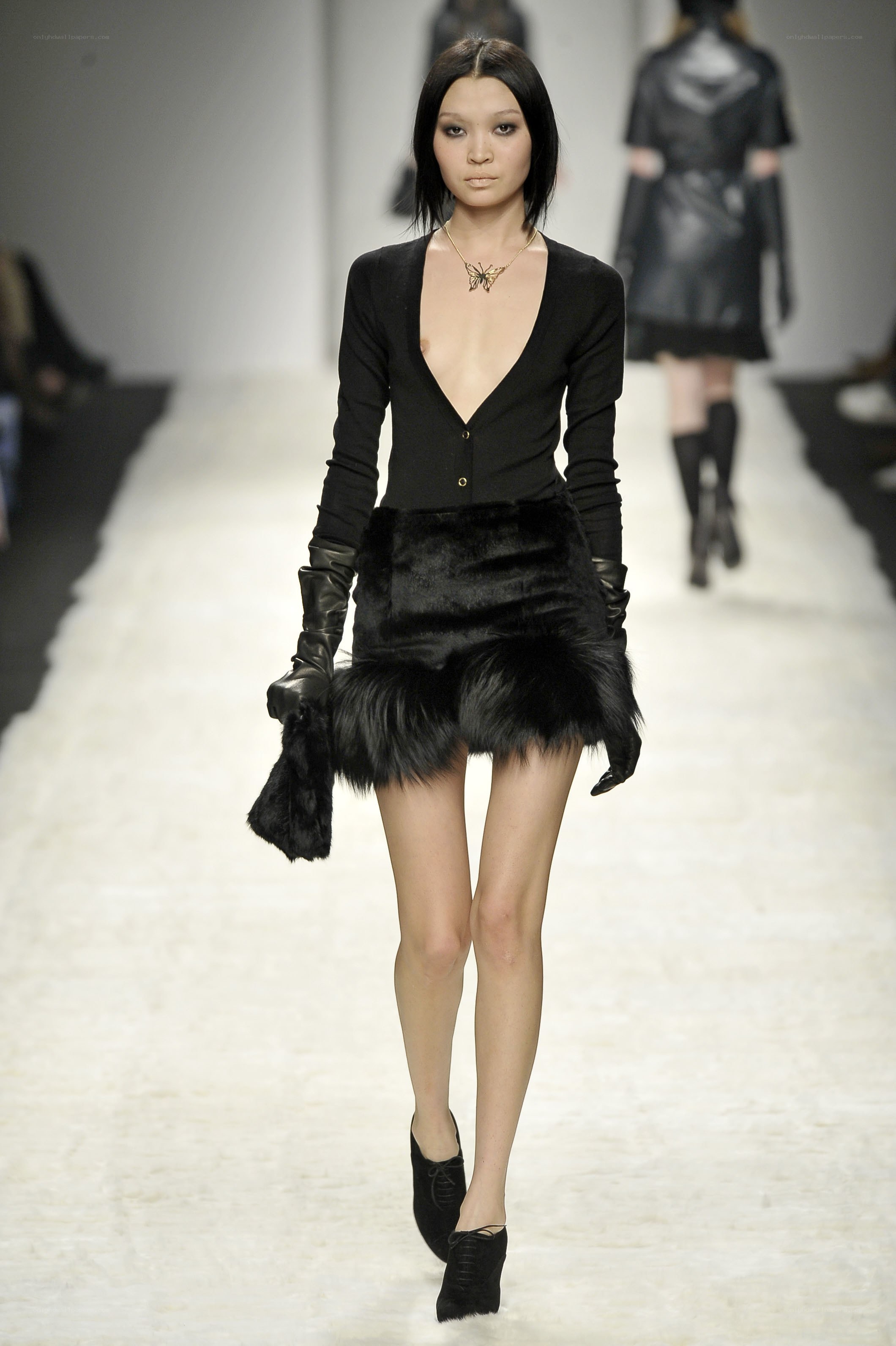 Model on runway in black outfit