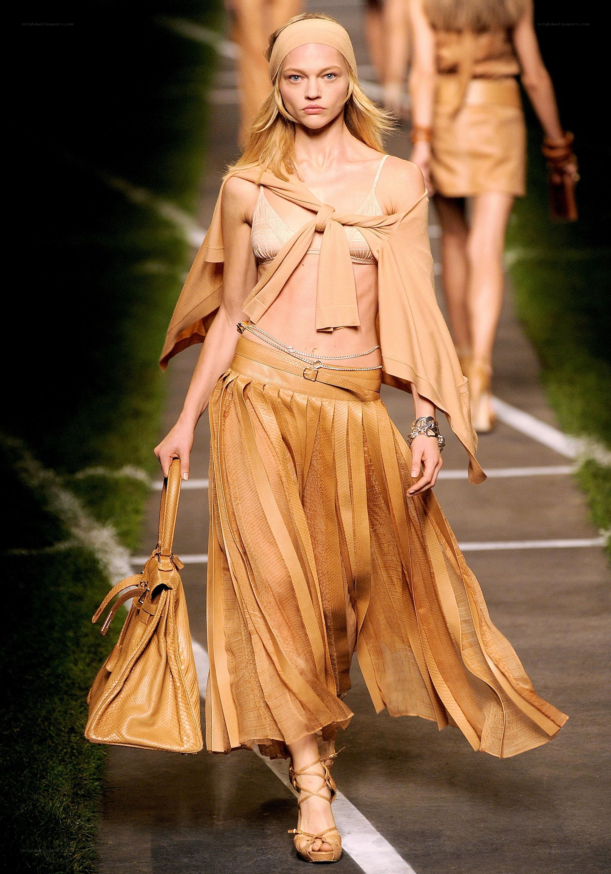 Model on runway in tan outfit