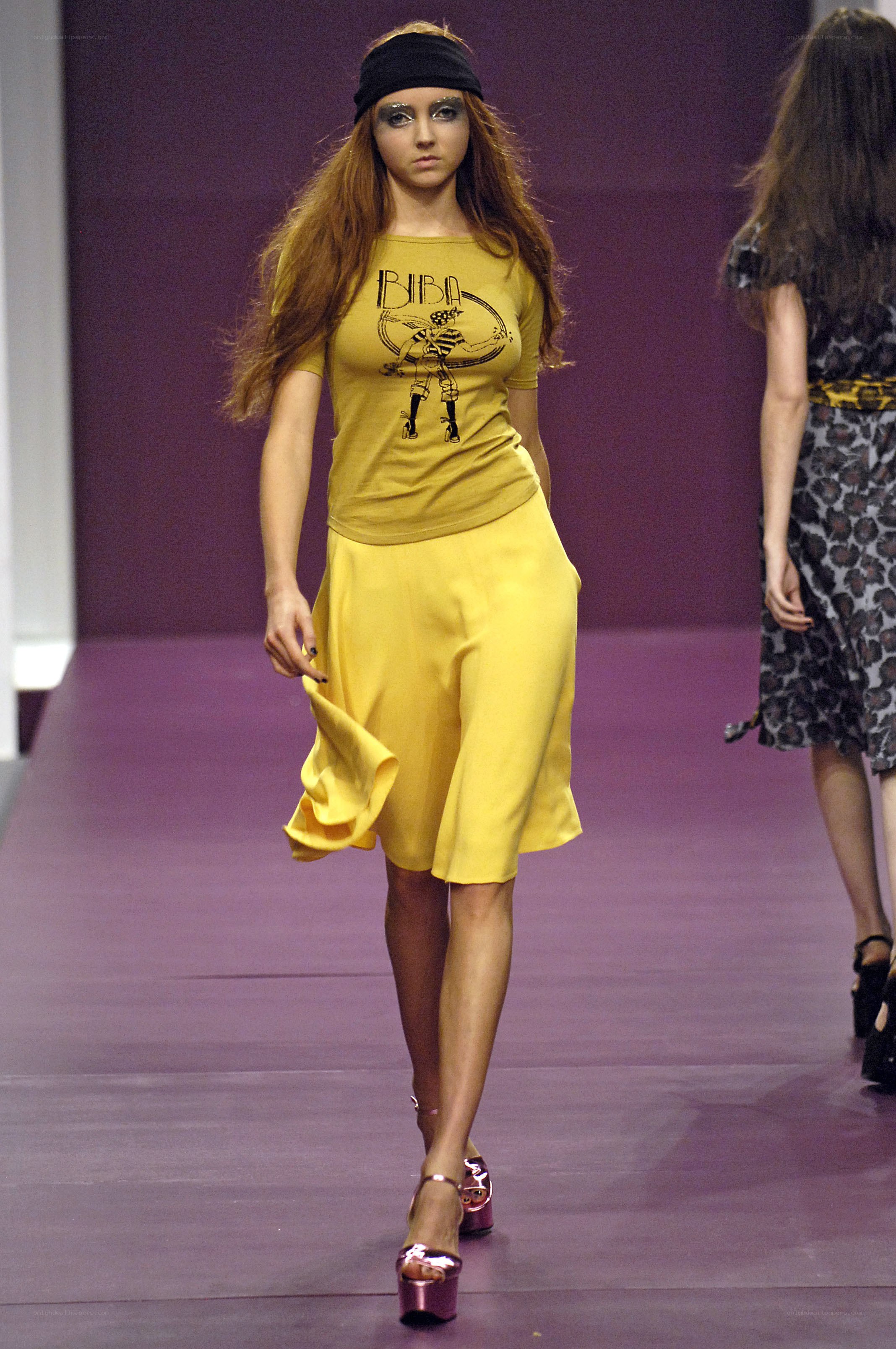 Model on runway in yellow outfit