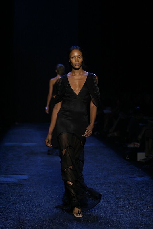 Model walks runway in black dress