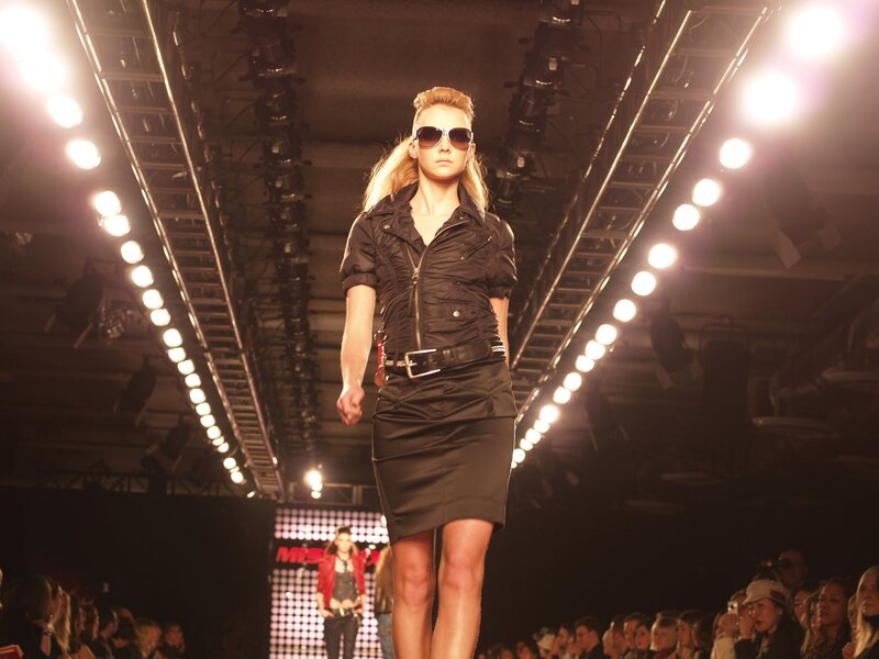 Model walks runway in black outfit
