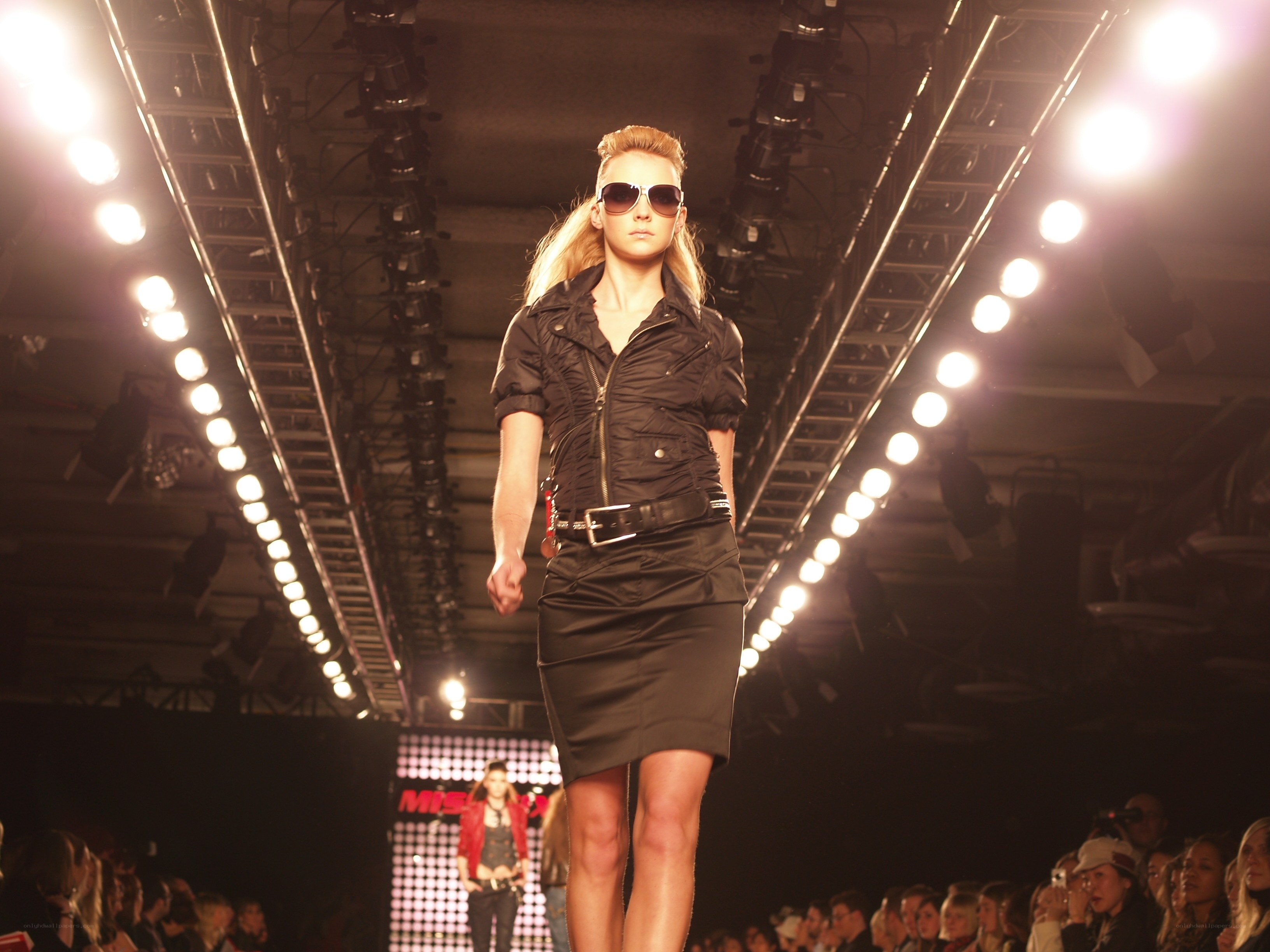 Model walks runway in black outfit