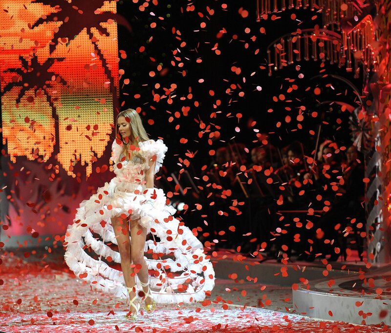 Model walks runway in white dress