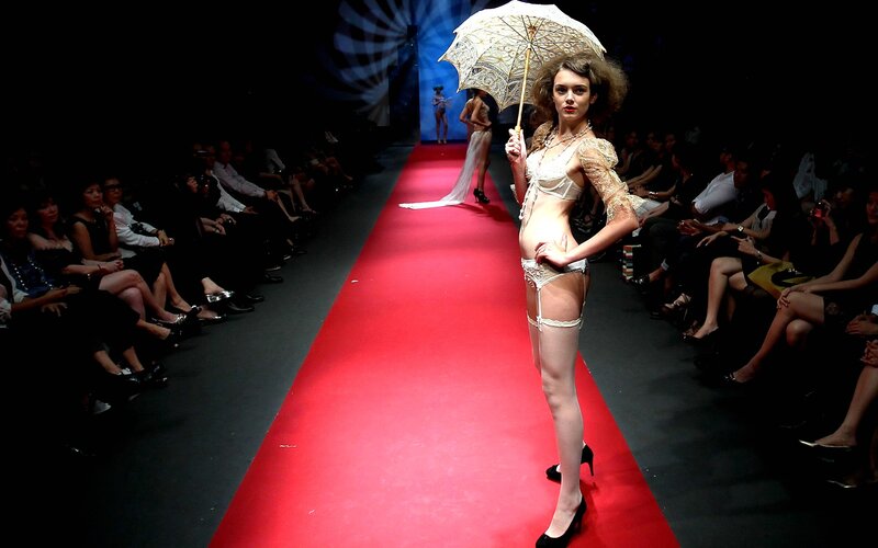 Model walks runway with parasol