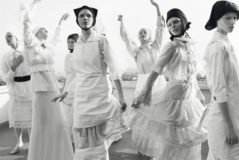 models in white dresses on rooftop