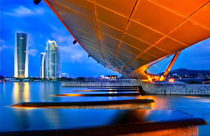 Modern bridge at dusk with city skyline