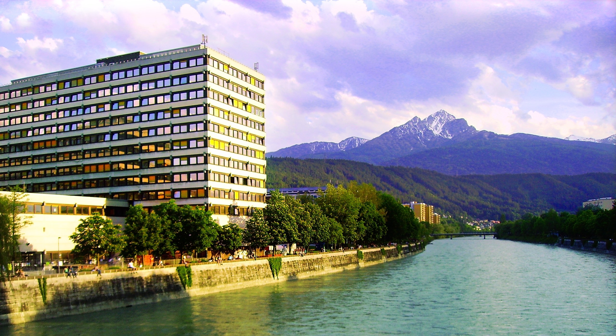 Modern building by a river with mountains