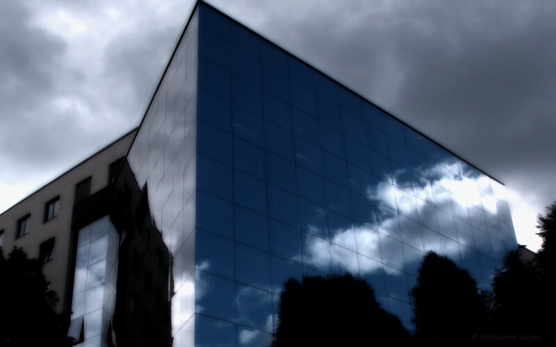 modern glass building under cloudy sky