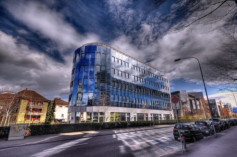 Modern glass building under cloudy sky