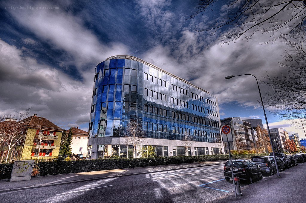 Modern glass building under cloudy sky