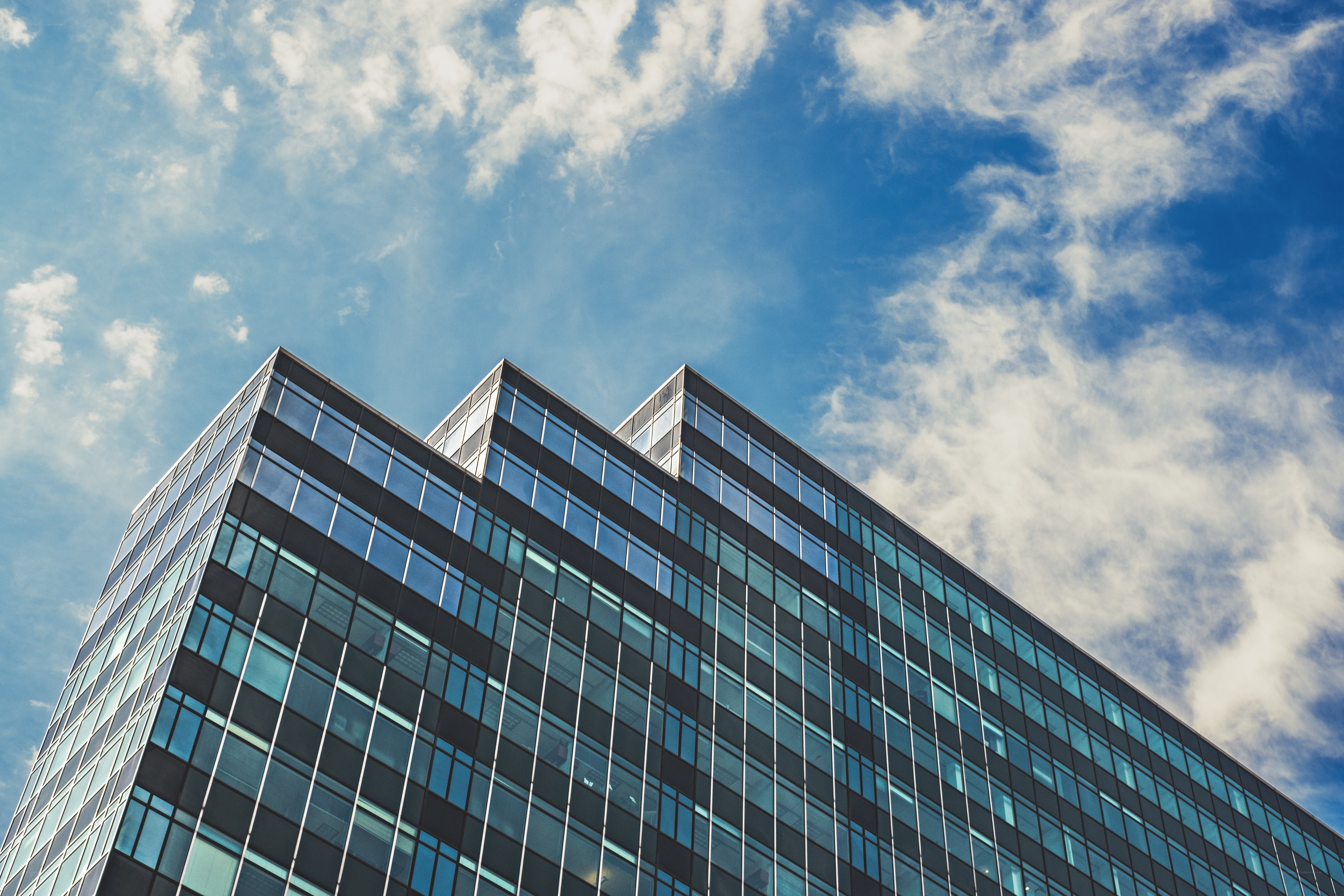 Modern glass skyscraper against blue sky