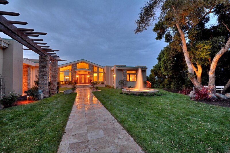 Modern home with fountain at dusk