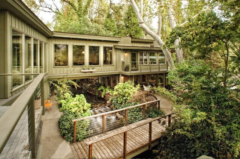 Modern home with stream and bridge