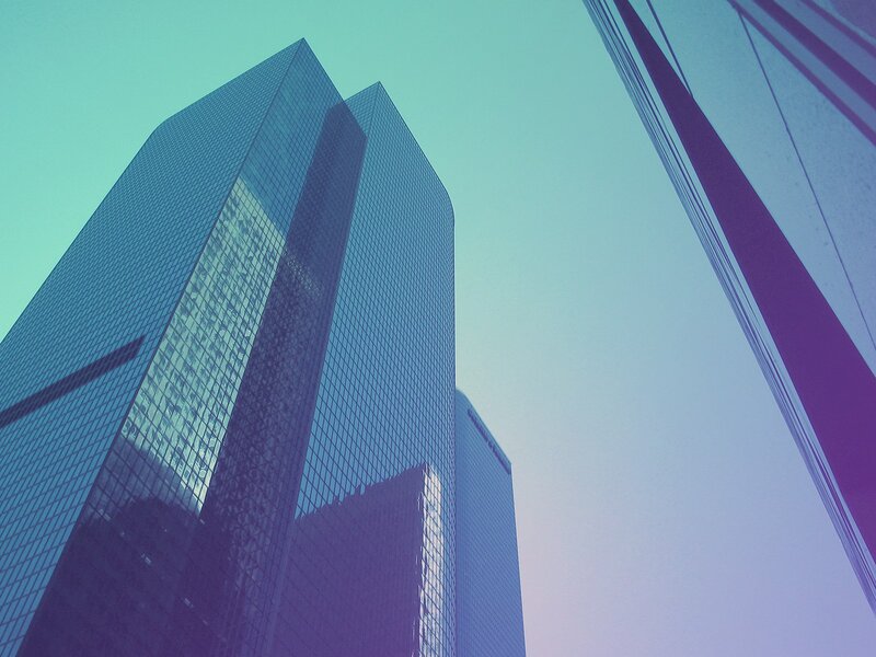 Modern skyscrapers under a colorful sky