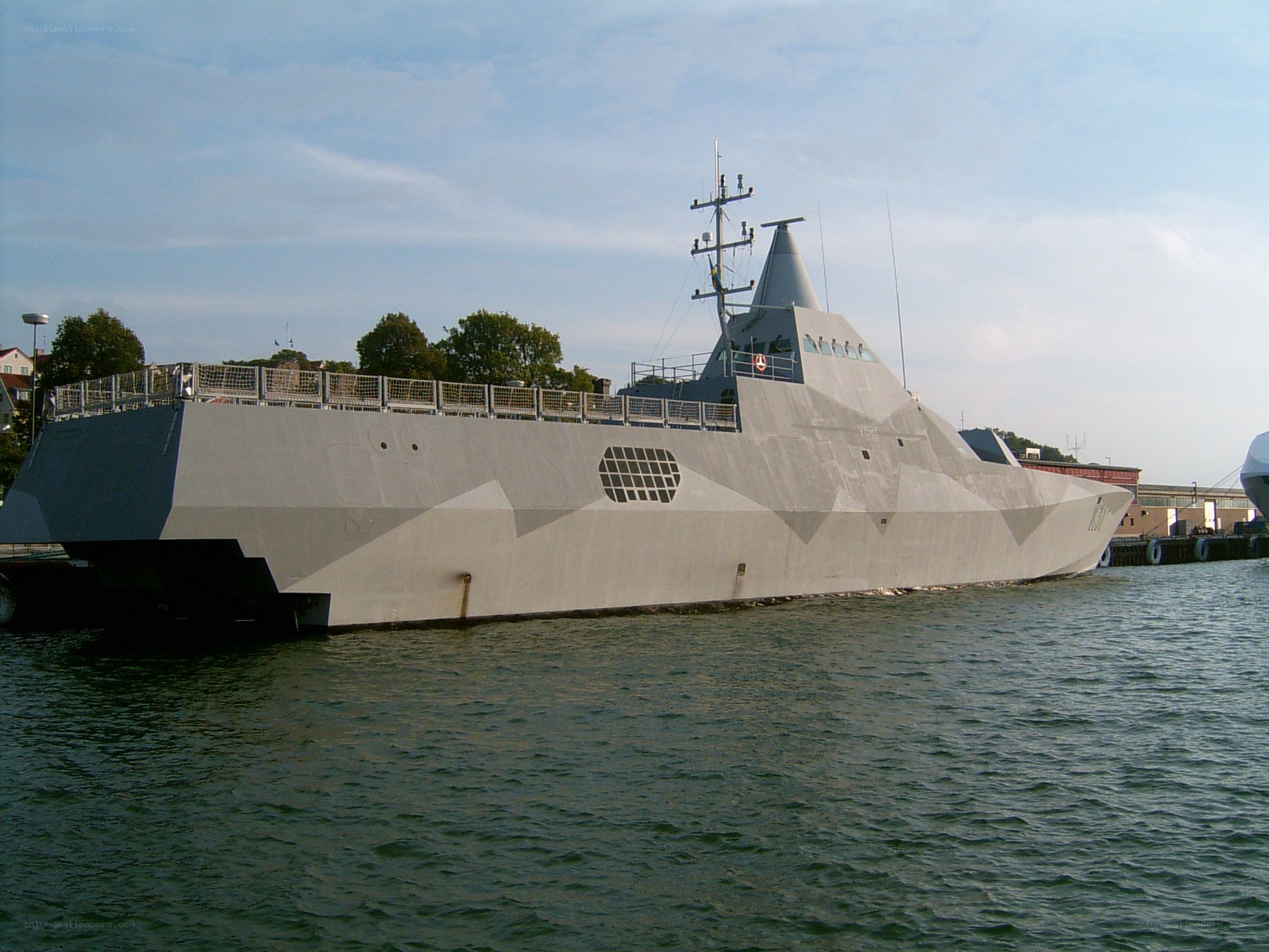 modern stealth warship in harbor