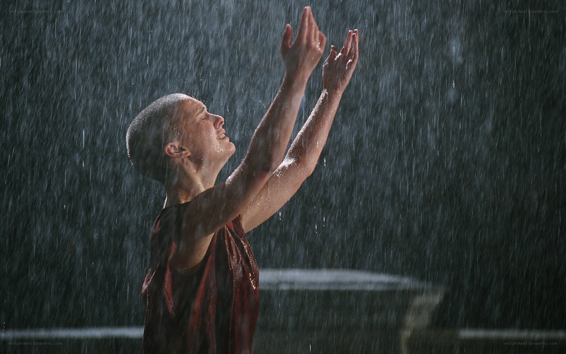 monk in rain with arms raised