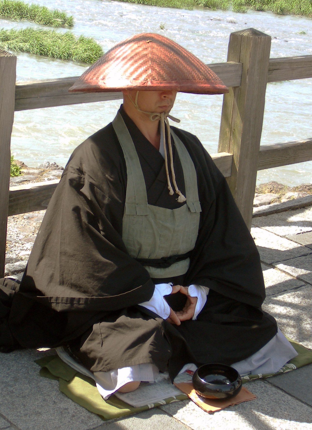 Monk meditating by a river