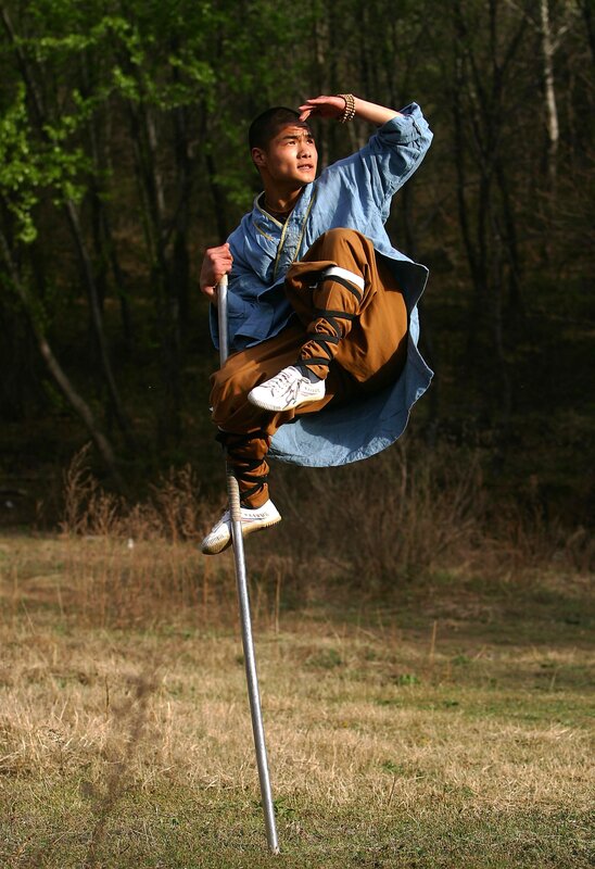 Monk performing martial arts on pole