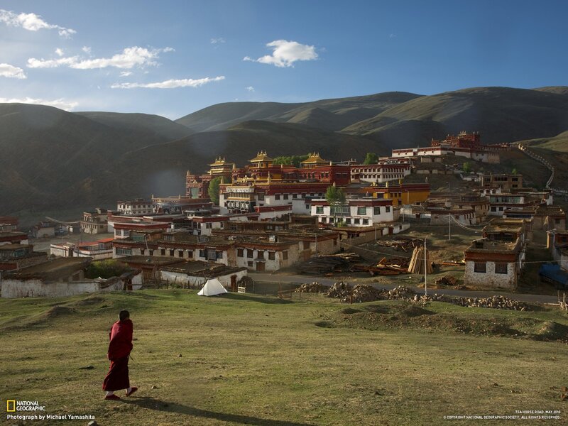 Monk walking near a Tibetan monastery