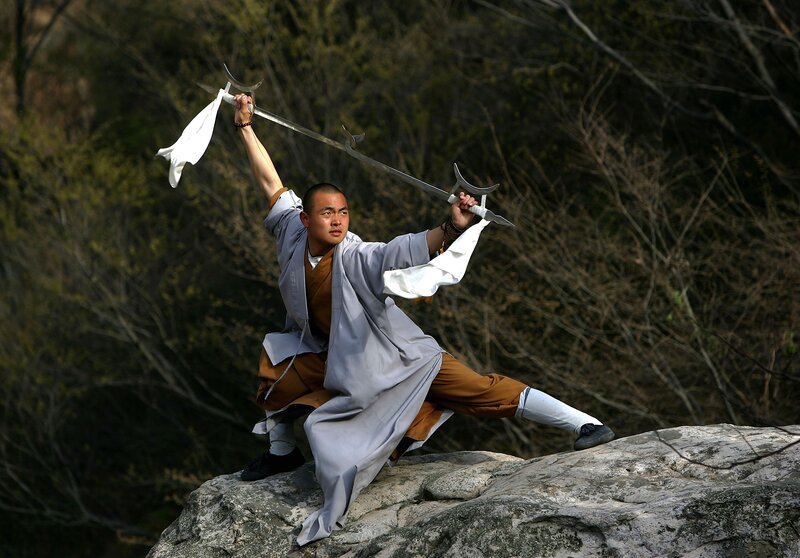 Monk wielding a sword on a rock