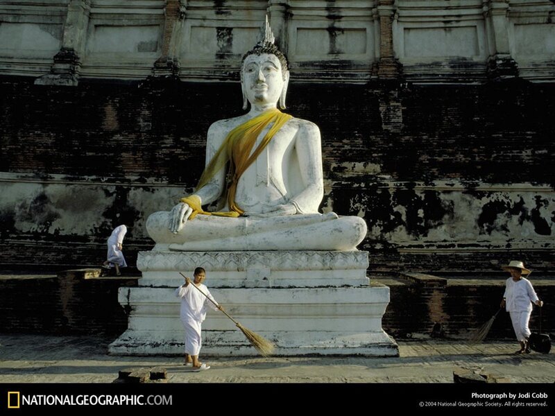 Monks cleaning near Buddha statue