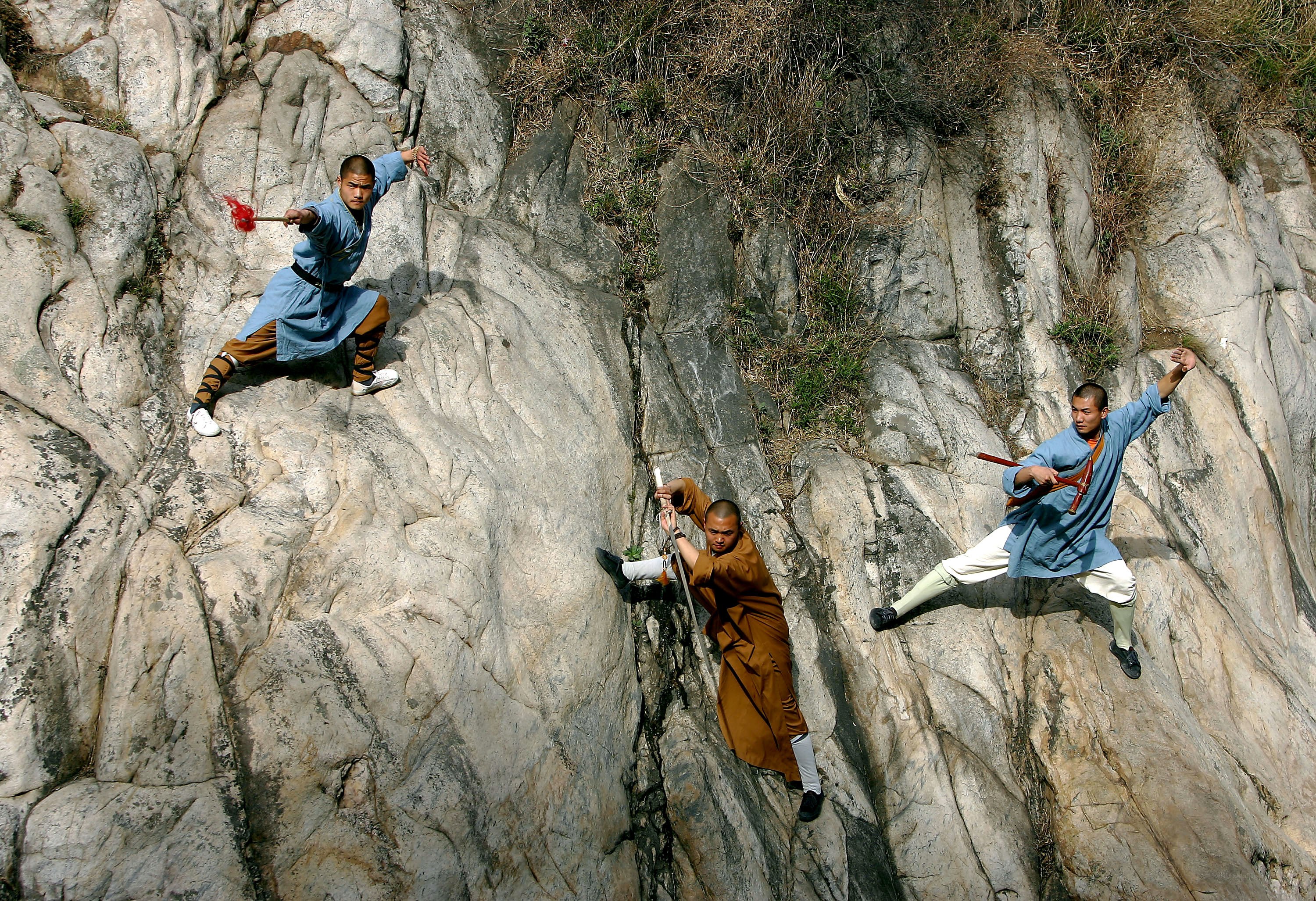 Monks practicing martial arts on a cliff