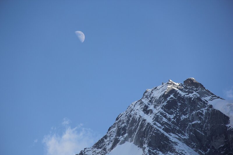Moon above snowy mountain peak