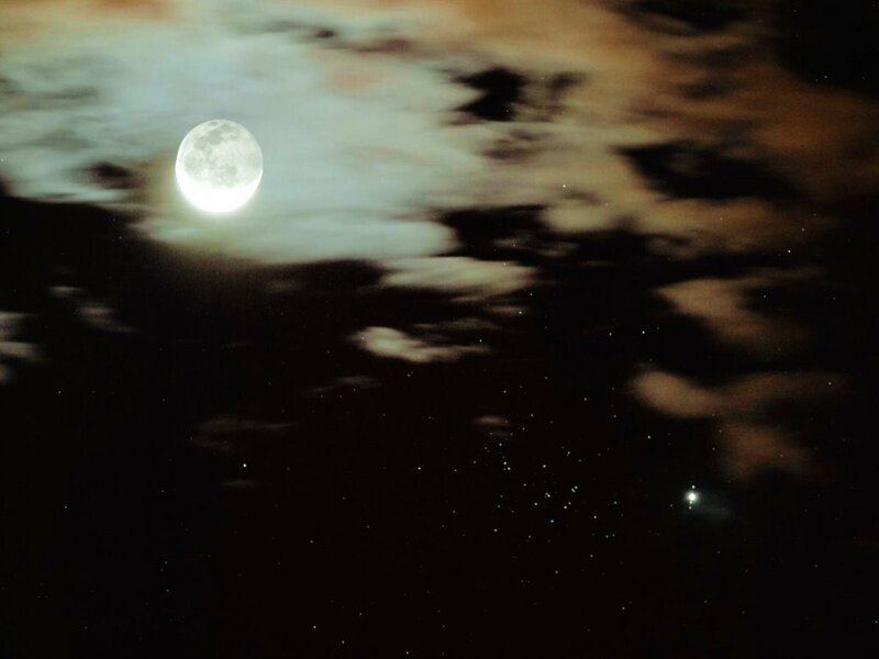 Moon and stars in cloudy sky