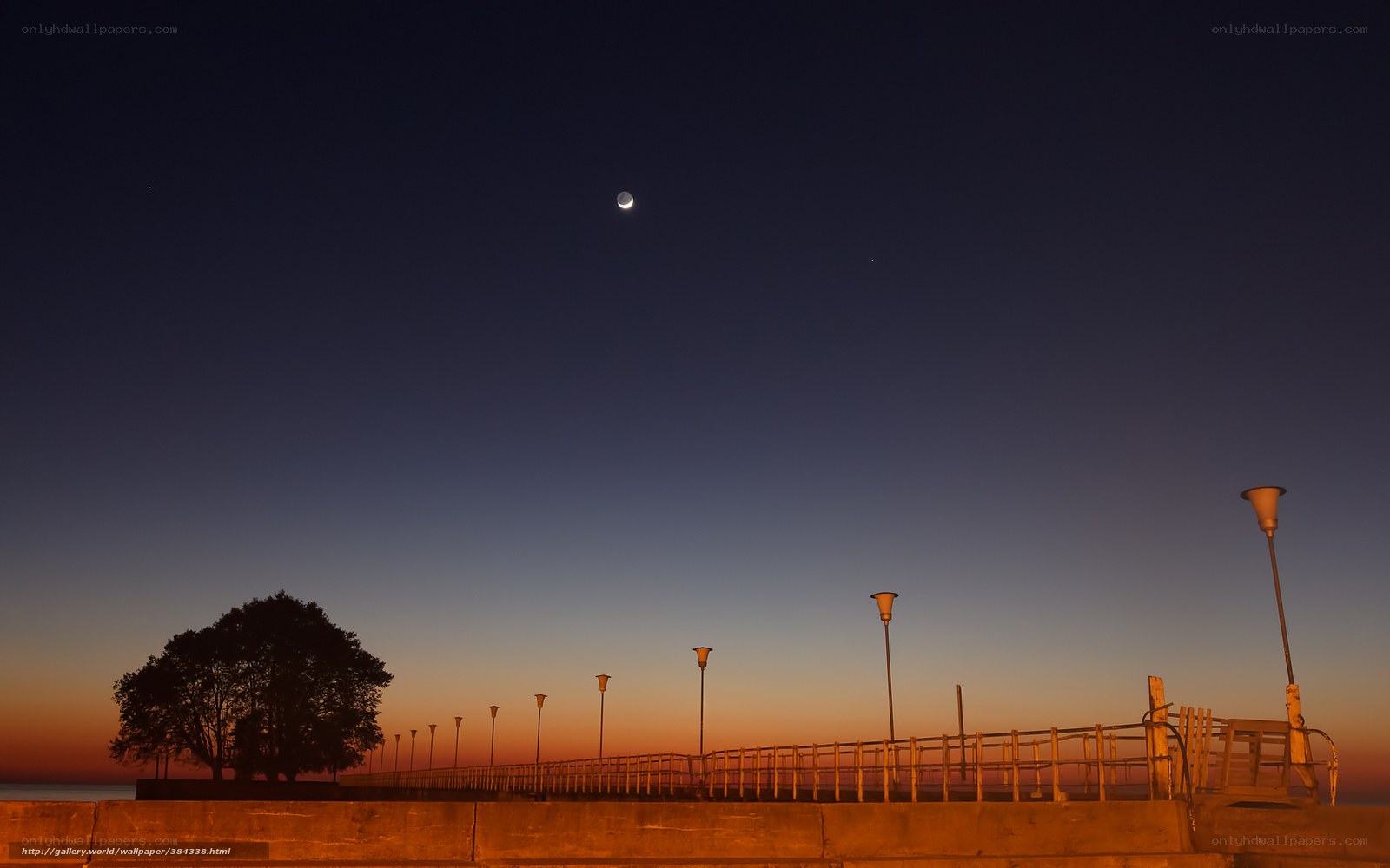 Moon and stars over a pier