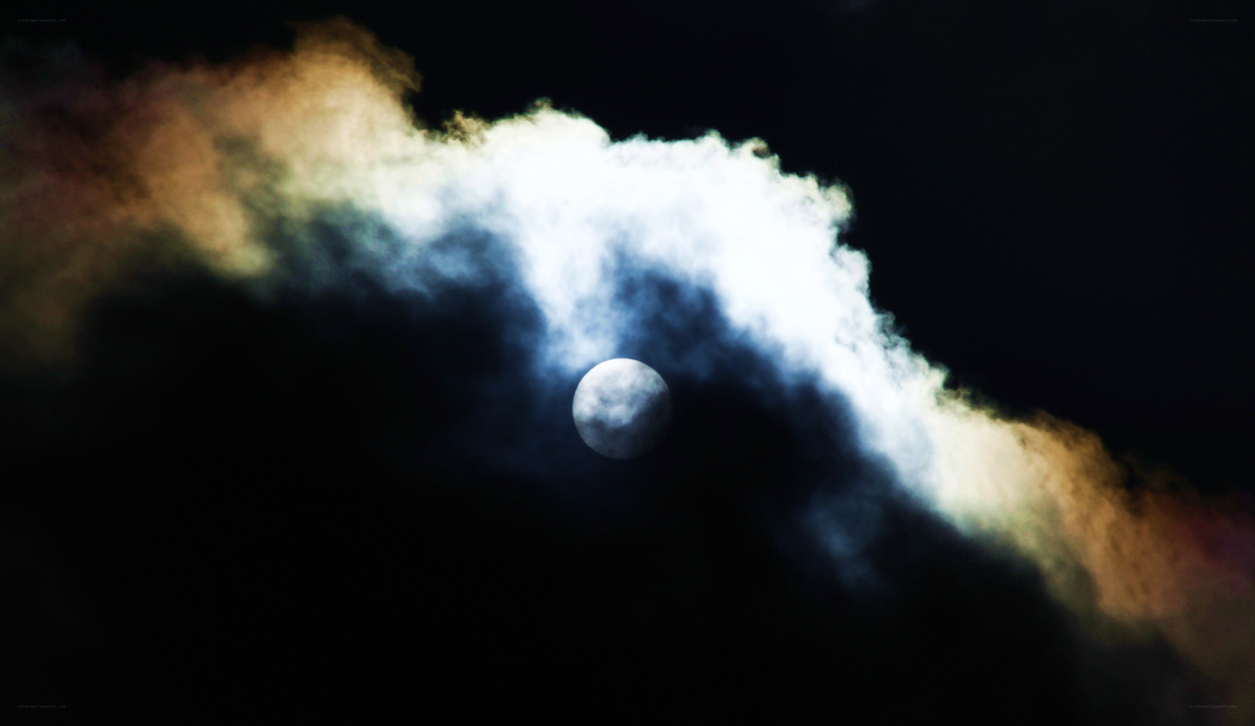 Moon behind clouds at night