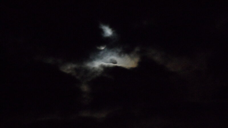 Moon behind clouds at night