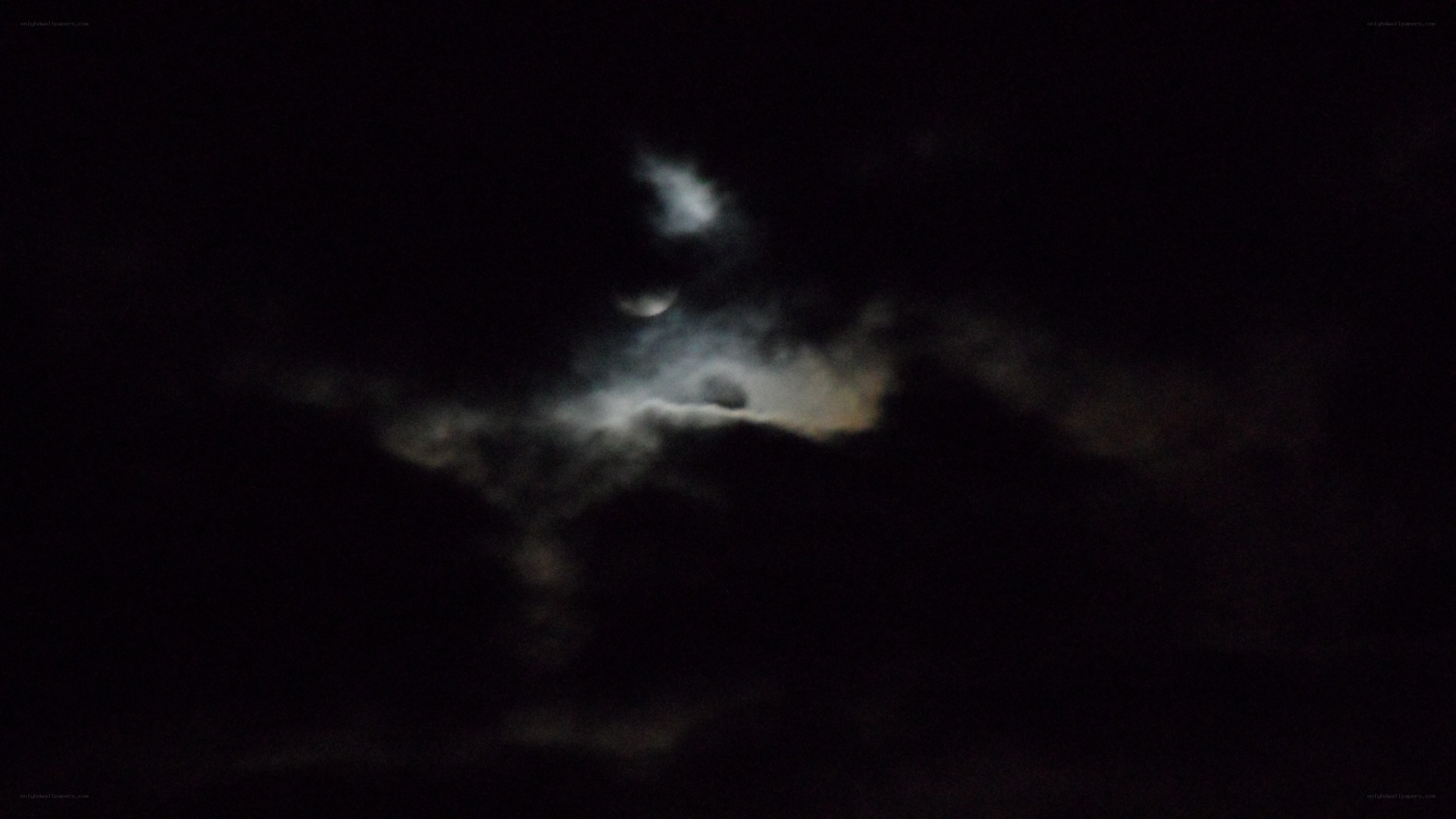Moon behind clouds at night