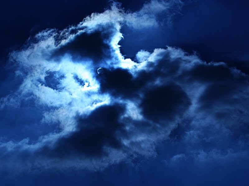 Moon behind clouds at night