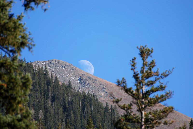 Moon behind mountain peak