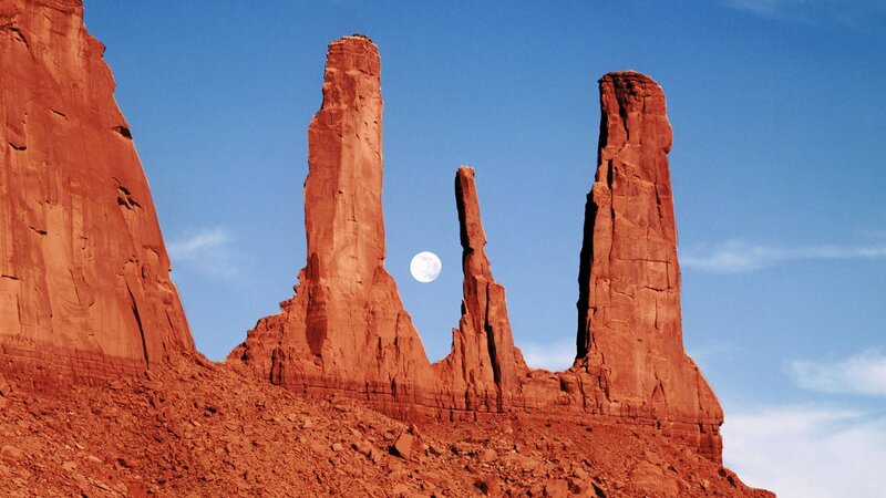 Moon between red rock spires