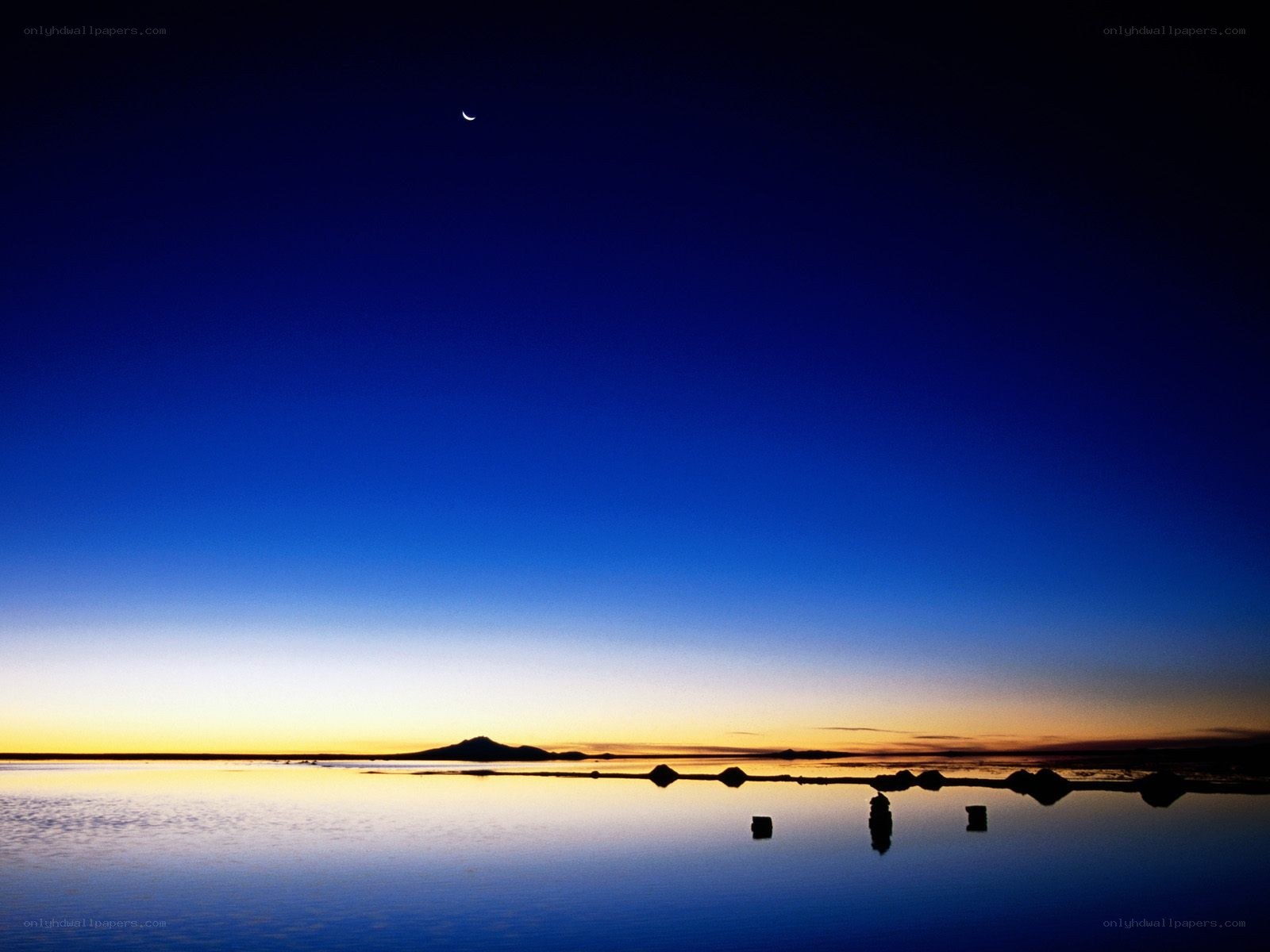 Moon over a calm lake at dusk