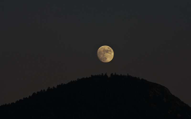 Moon over a silhouetted hill