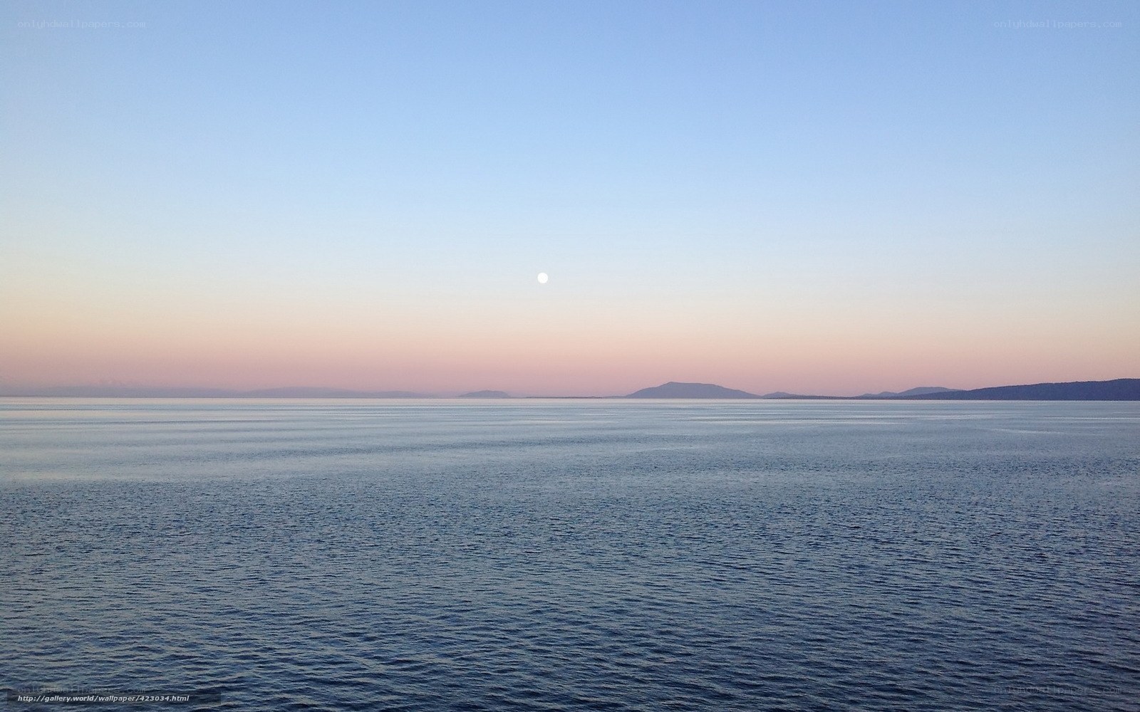 Moon over calm sea at dusk