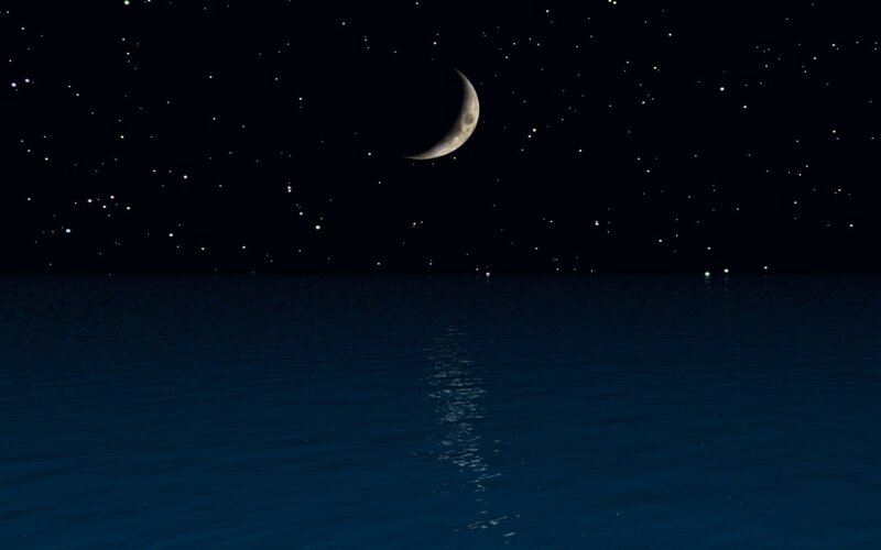 Moon over calm sea at night