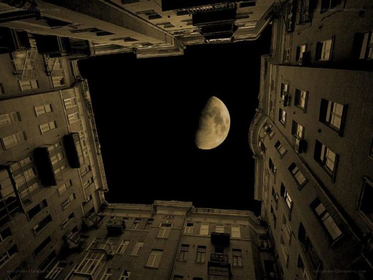 Moon over city buildings