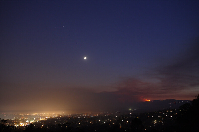 Moon over city with wildfire