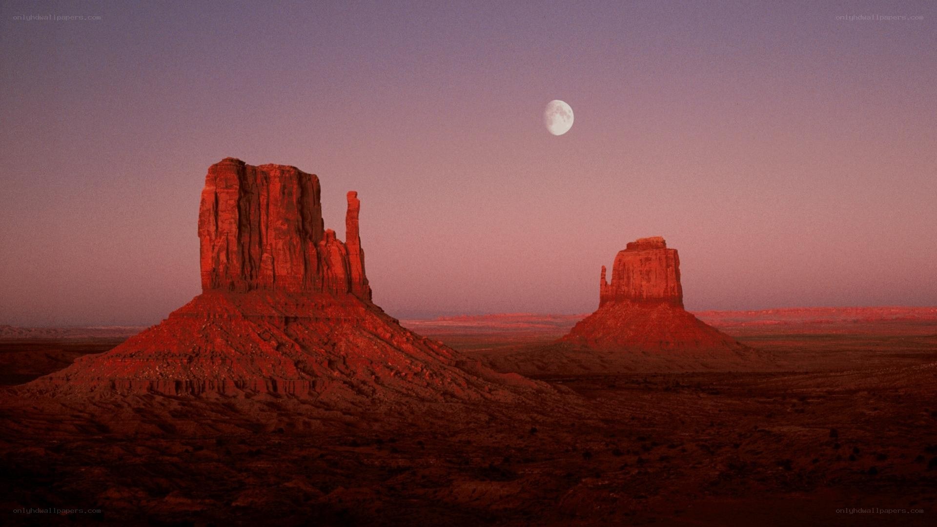 Moon over desert rock formations