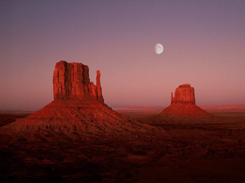 Moon over desert rock formations