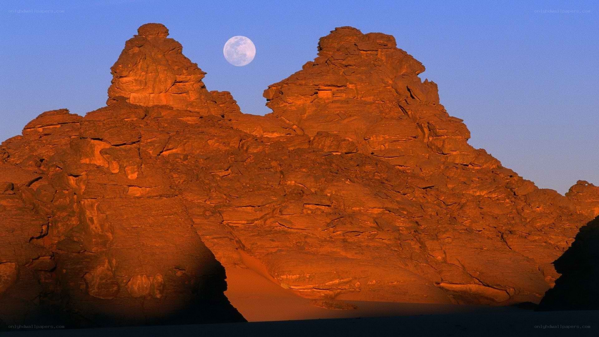 Moon over desert rock formations