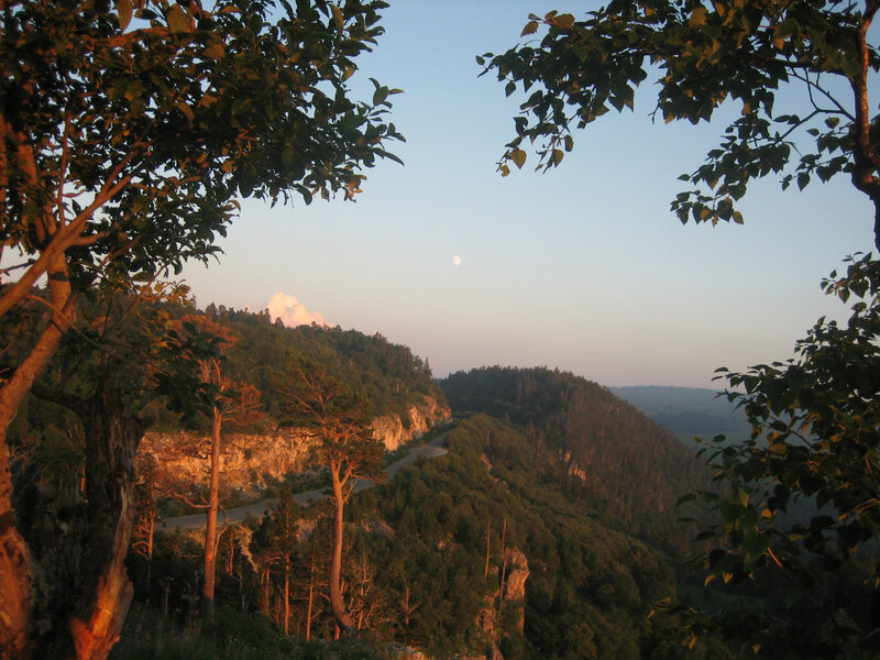 Moon over forested hills